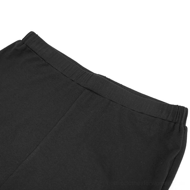 Close-up detail shot of elastic waistband on black gothic lace flare leggings, showing high-waist construction and solid black stretch fabric