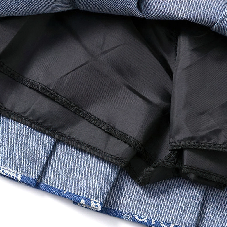Pleated letter print denim mini skirt close detail, typography coverage and denim quality on dark blue