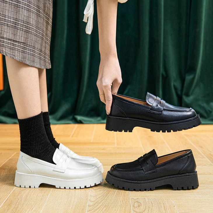 Black and white leather platform loafers, overhead flat lay showing both color options available