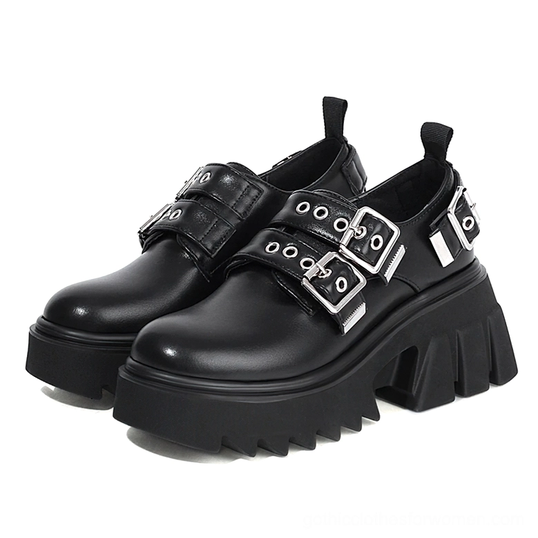 Front three-quarter view of gothic platform loafers featuring matte leather, dual metal buckles, and commanding serrated thick sole