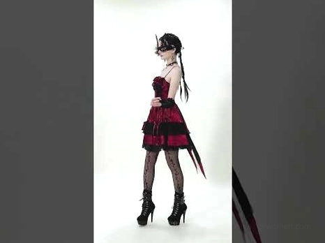 Side profile view of burgundy velvet gothic Lolita mini dress highlighting asymmetrical tail hem and ruffled bust design