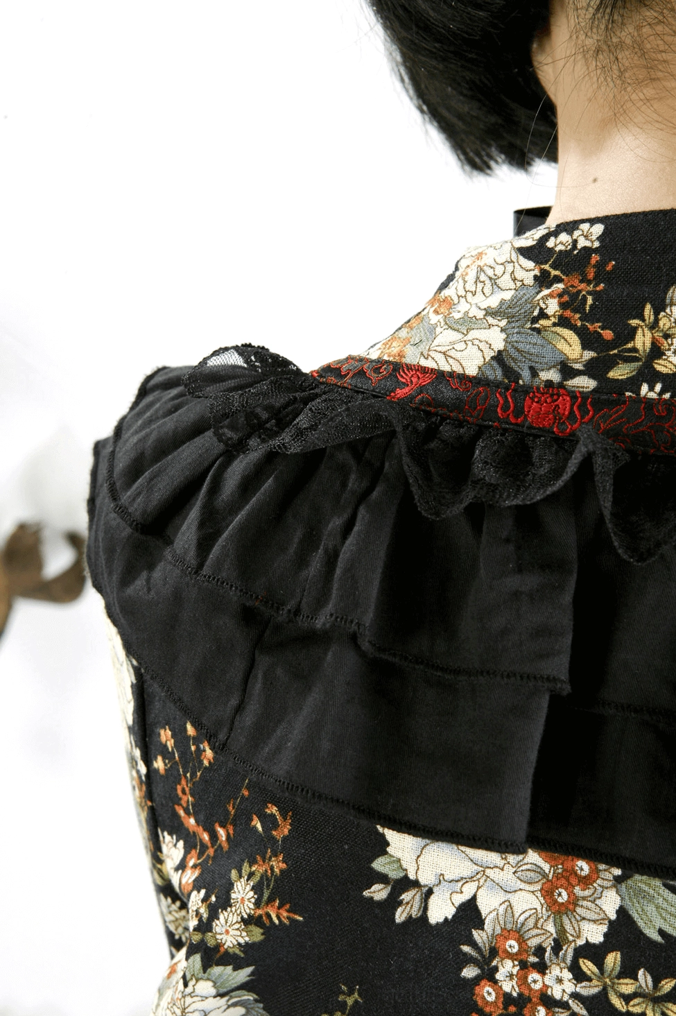 Gothic lolita dress back view showcasing detachable bow and ruffled hem construction detail