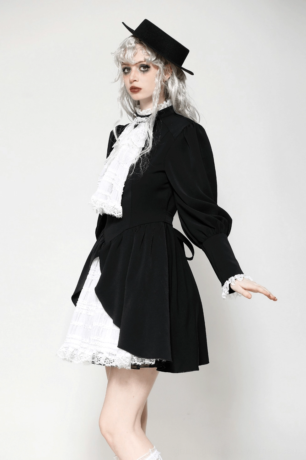 Side view of Victorian gothic black and white lace dress on model - showing silhouette, ruffled layers, and sleeve construction