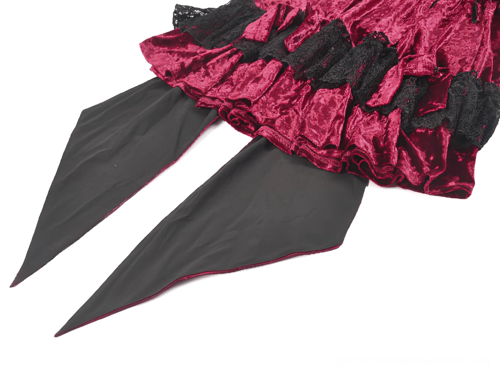 Close-up detail view of ruffled velvet skirt layering, black lace trim, and two pointed detachable black tail pieces
