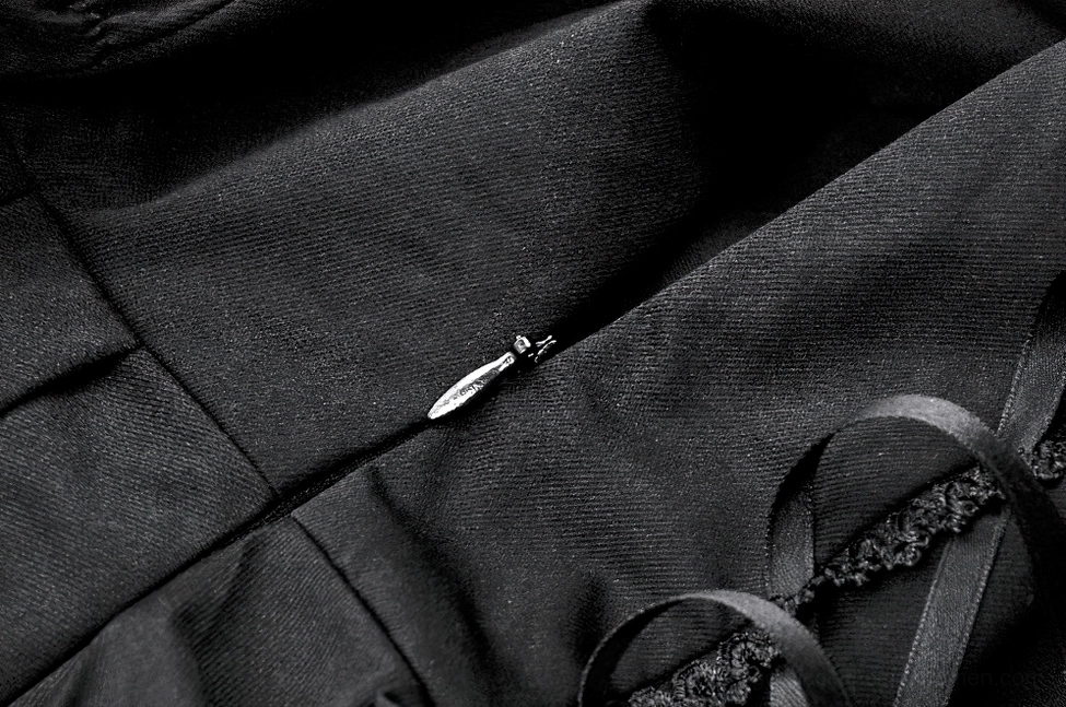 Alternative fashion black and white ruffled gothic dress detail showing construction and layer design