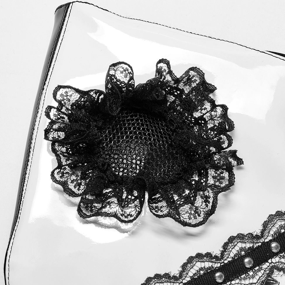 Close-up detail of black lace flower with mesh center on glossy white patent leather gothic mask