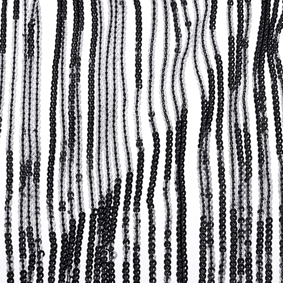 Flat lay close-up of black sequin tassel fringe showing detailed texture and hanging strands