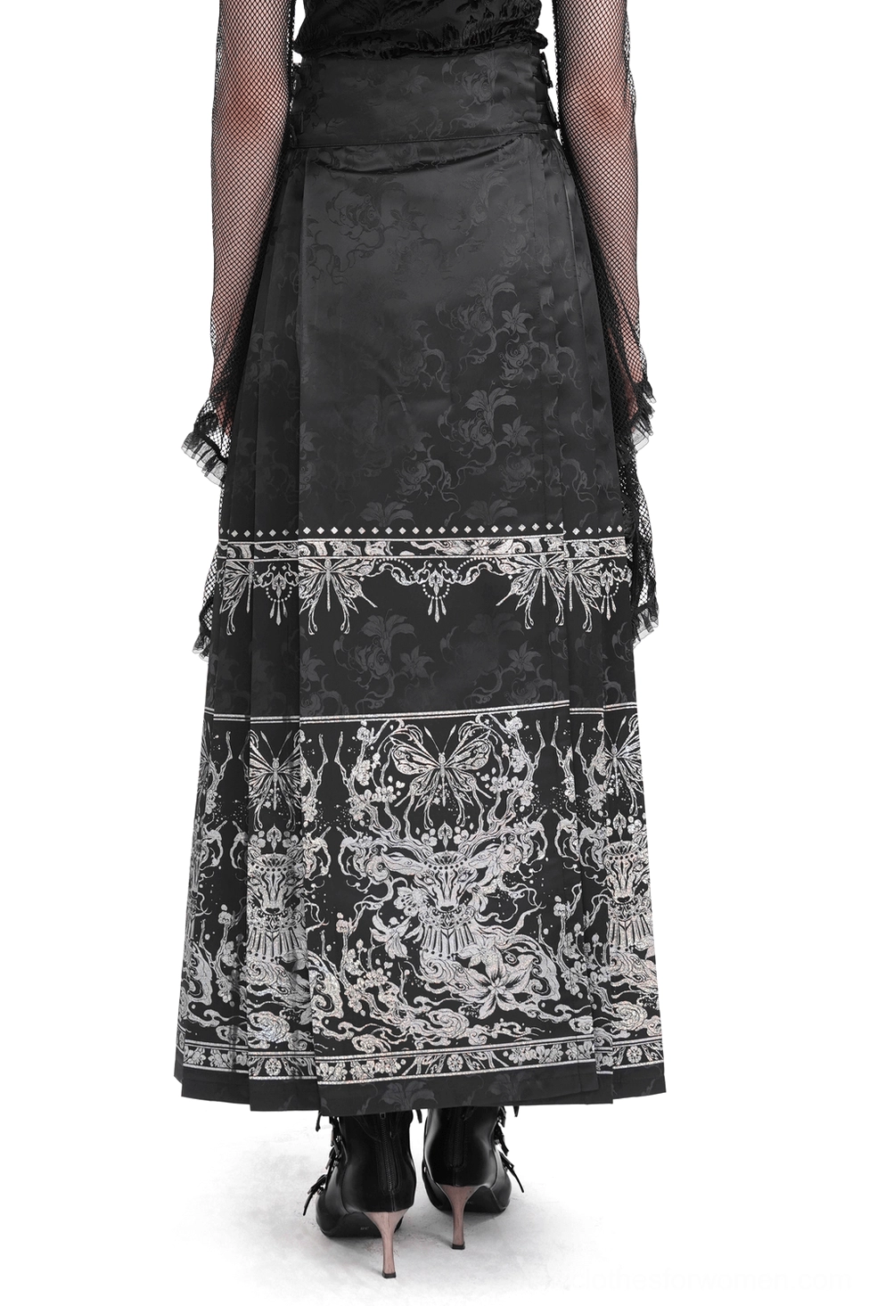 Black gothic maxi skirt rear view worn by female model displaying high-waisted design with embroidered trim bands and flowing silhouette in studio setting
