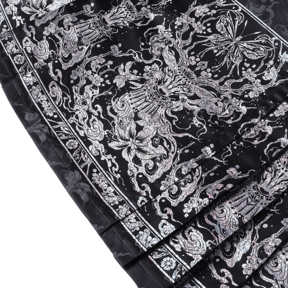 Side profile detail of black gothic maxi skirt worn by model showcasing draping silhouette and embellishment placement