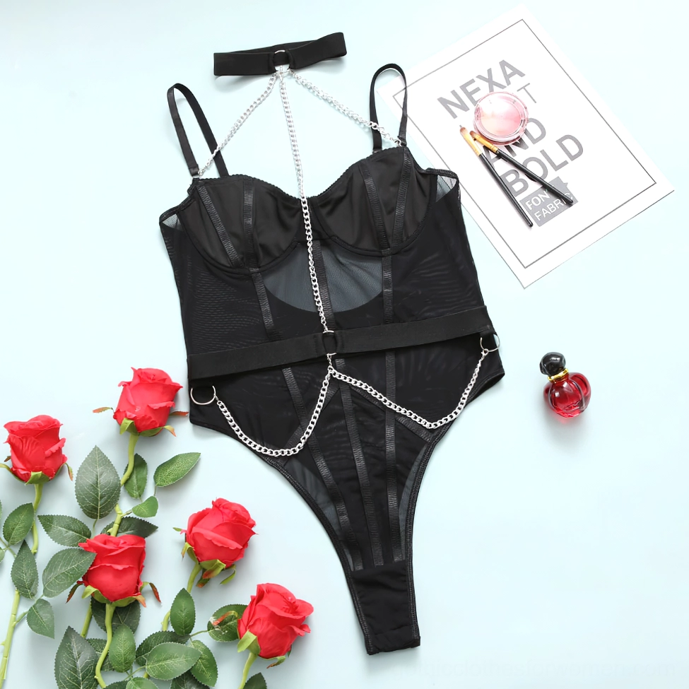 Black gothic mesh bodysuit flat lay with decorative floral props, chain harness design, overall product styling
