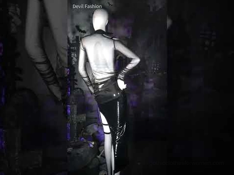 Gothic form-fitting sheer mesh crop top on bald model, back view paired with patent leather bottoms in dark setting