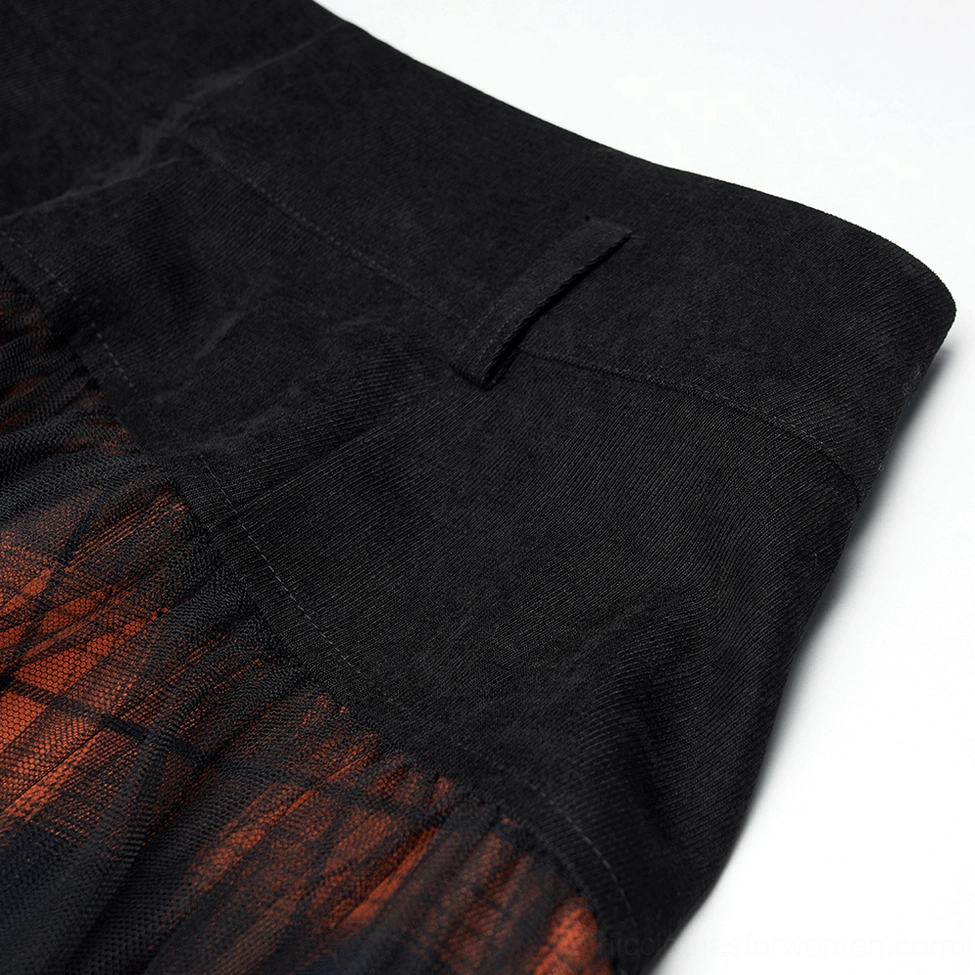 Close-up detail of black and orange plaid gothic mesh skirt waist showing solid black suede-style fabric and structured waistband construction