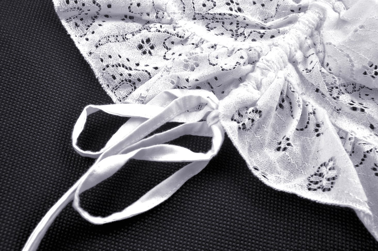 Side close-up of white gothic lace midi dress showing drawstring tie and ruched lace fabric construction