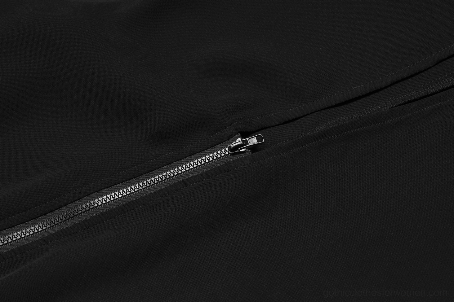 Close-up of black gothic midi skirt side zipper mechanism with adjustable dual-end system and silver metal zipper hardware on dark background