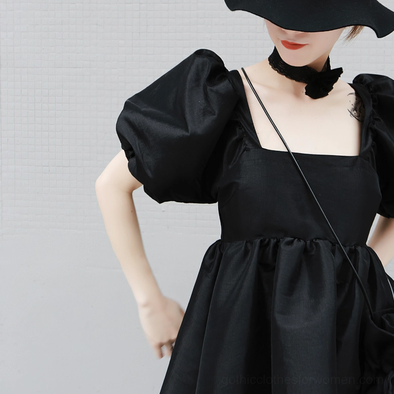 Shoulder detail of black gothic mini dress showing square neckline and puff sleeve volume