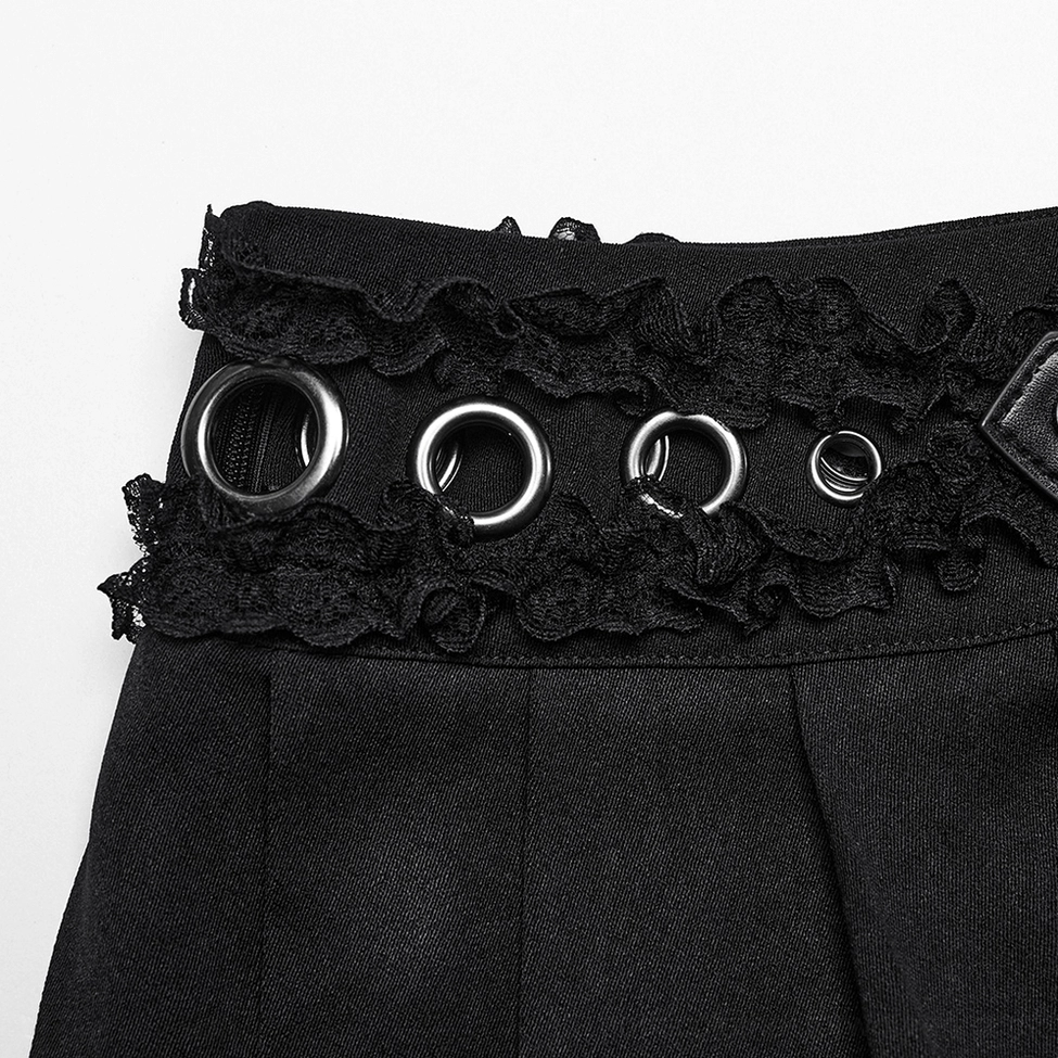 Macro close-up of black gothic pleated skirt showing multiple metal eyelets, ruffled lace trim, and premium fabric weave texture
