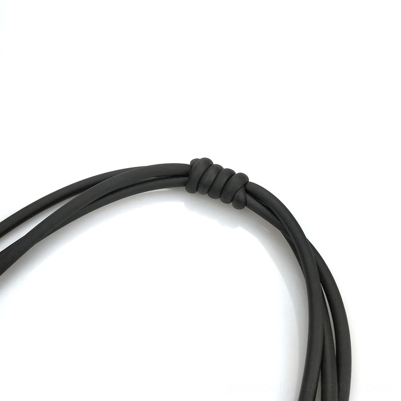 Close-up detail of adjustable knotted black rubber cord closure on gothic necklace
