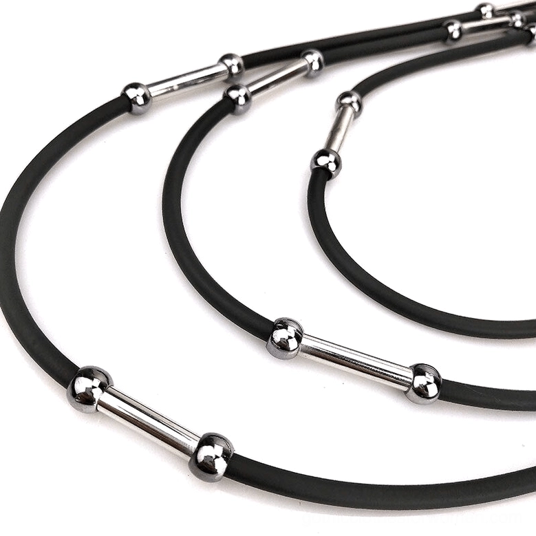 Close-up macro detail of black rubber cord with silver metal connectors on gothic necklace