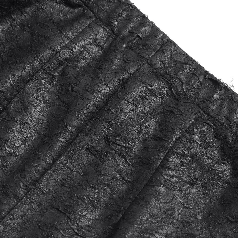 Detailed view of chain lace-up side panel on black gothic fishnet flare trousers