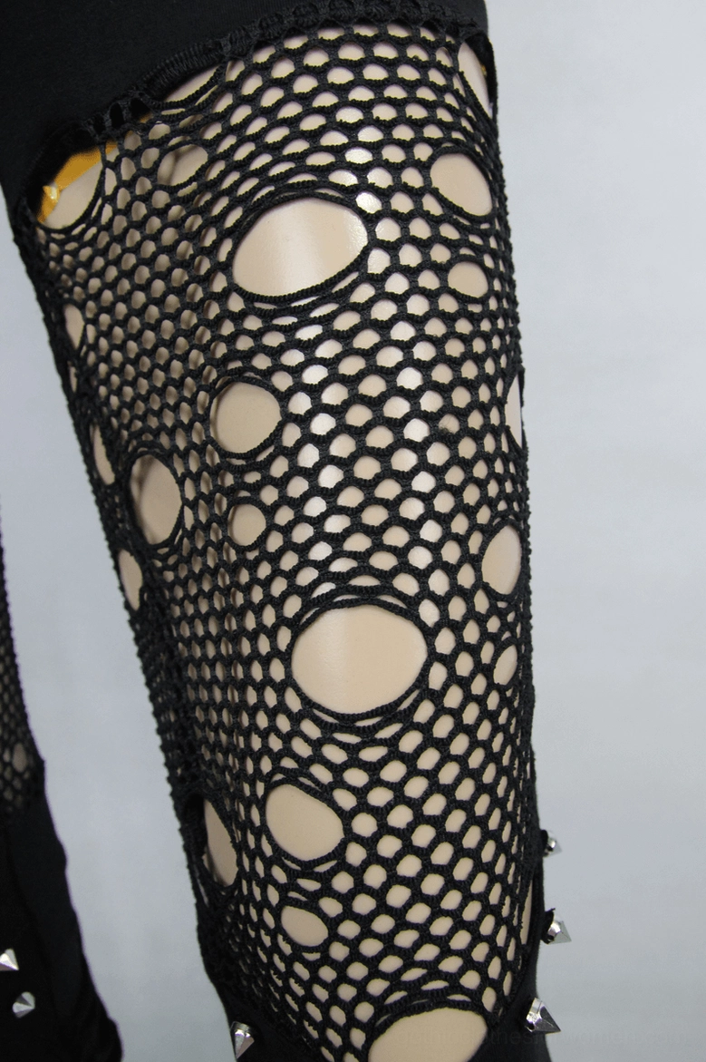 Close-up detail of fishnet cutout with metal studs on gothic pants