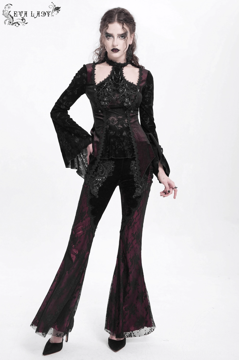 Close-up of embroidered lace appliqué on black velvet gothic pants showing intricate beadwork and embellishment craftsmanship