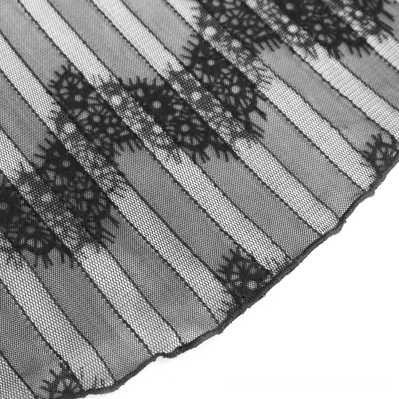 Macro close-up of black lace mesh fabric showing striped mesh base with floral lace pattern