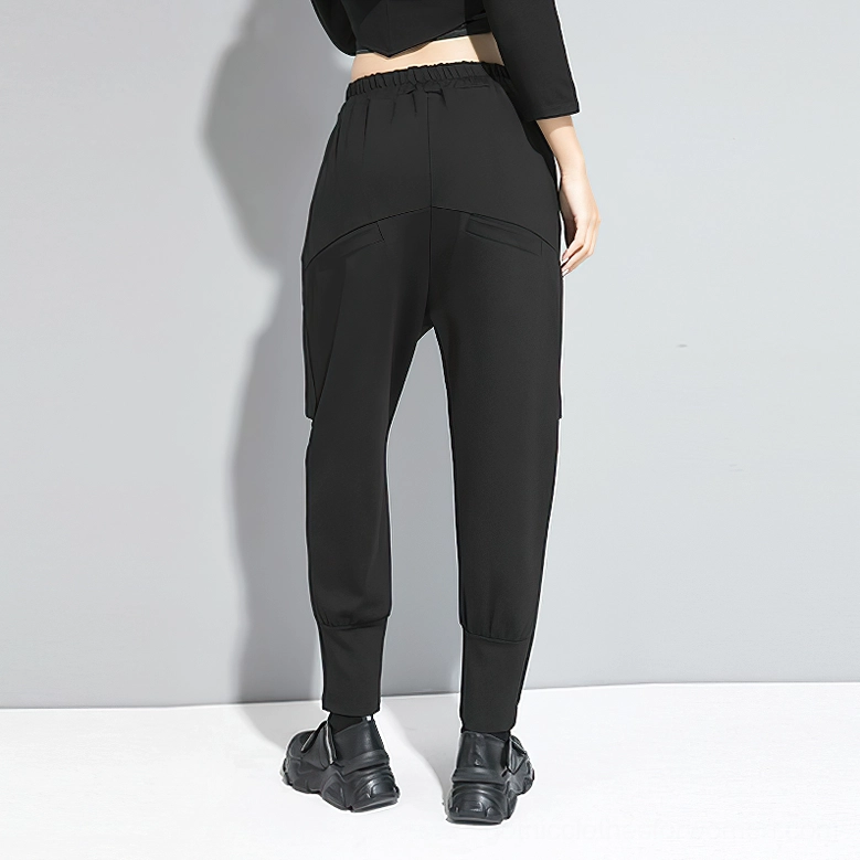 Black gothic harem trousers rear three-quarter view displaying drop crotch and elastic waist design
