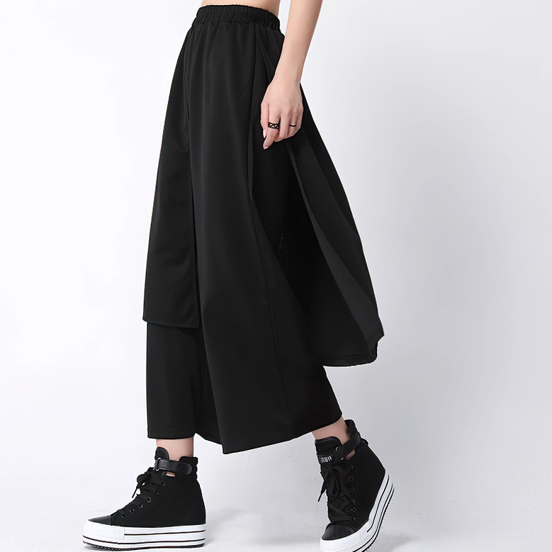 Black gothic casual pants with oversized side overlay, cropped ankle length, side profile view