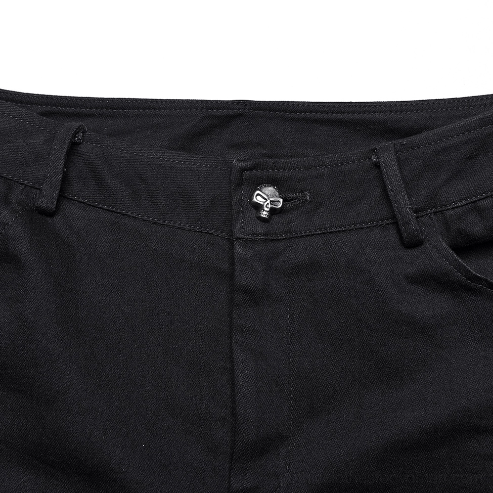 Close-up detail of skull-shaped button and waistband on black gothic lace flared pants