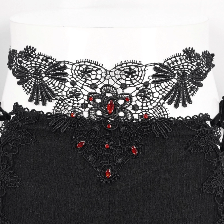 Close-up detail of gothic trousers waistband featuring black floral lace and crimson gemstone decorations