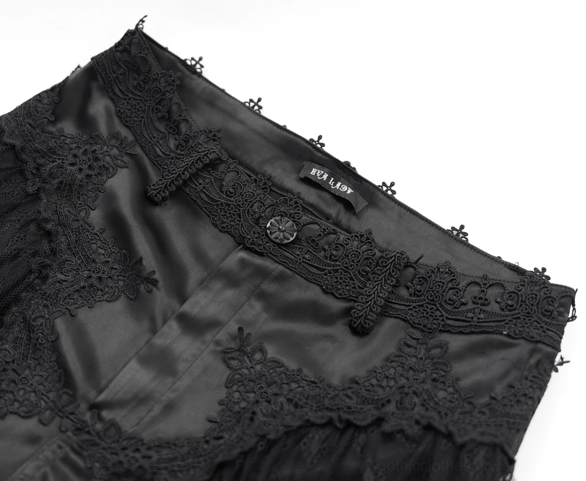 Close-up detail of gothic pants waistband featuring embroidered lace trim and branded satin fabric