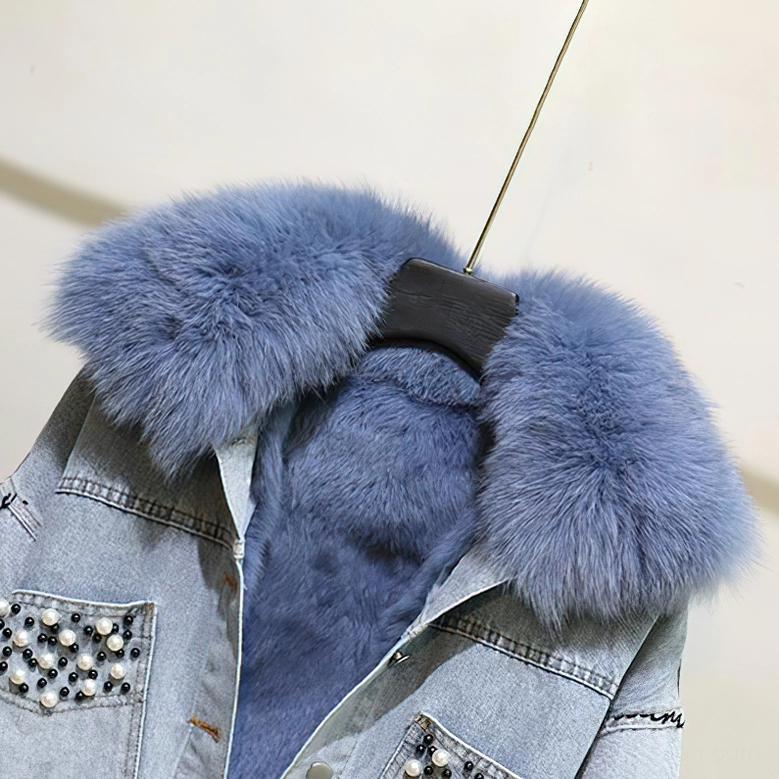 Close-up of fluffy light blue fox fur collar detail on gothic denim parka with pearl beading