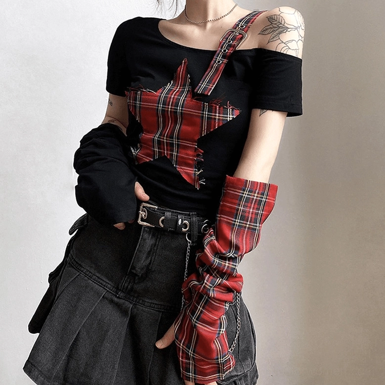 Close-up of shoulder strap featuring metal buckle and eyelet fasteners, red tartan plaid pattern with industrial-gothic hardware accents