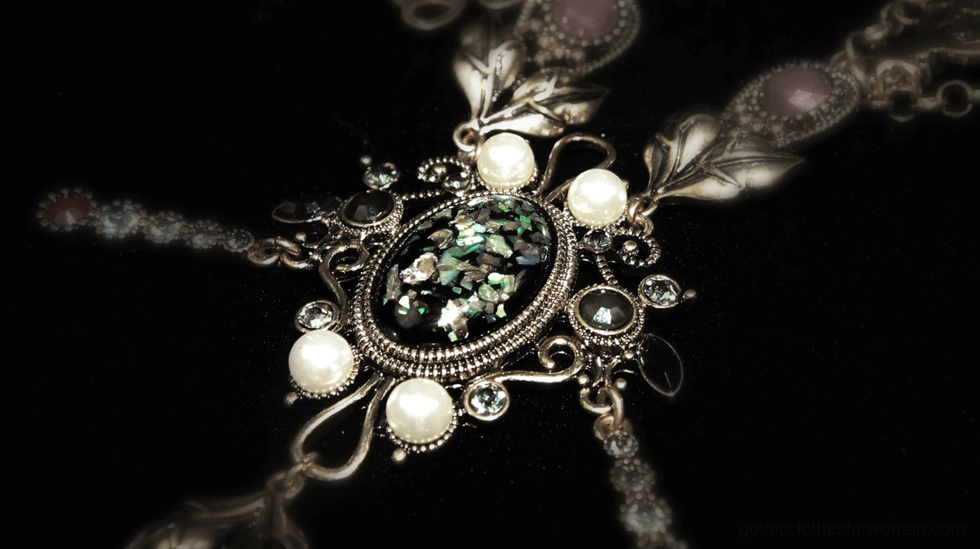 Gothic pearl necklace pendant macro close-up, faux pearls multi-faceted gems floral filigree on black velvet