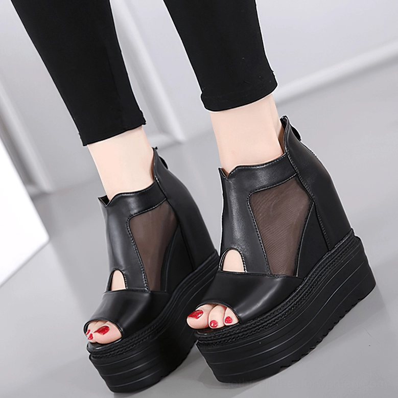 Close-up detail of black gothic peep-toe platform boots showing thick sole construction and leather stitching