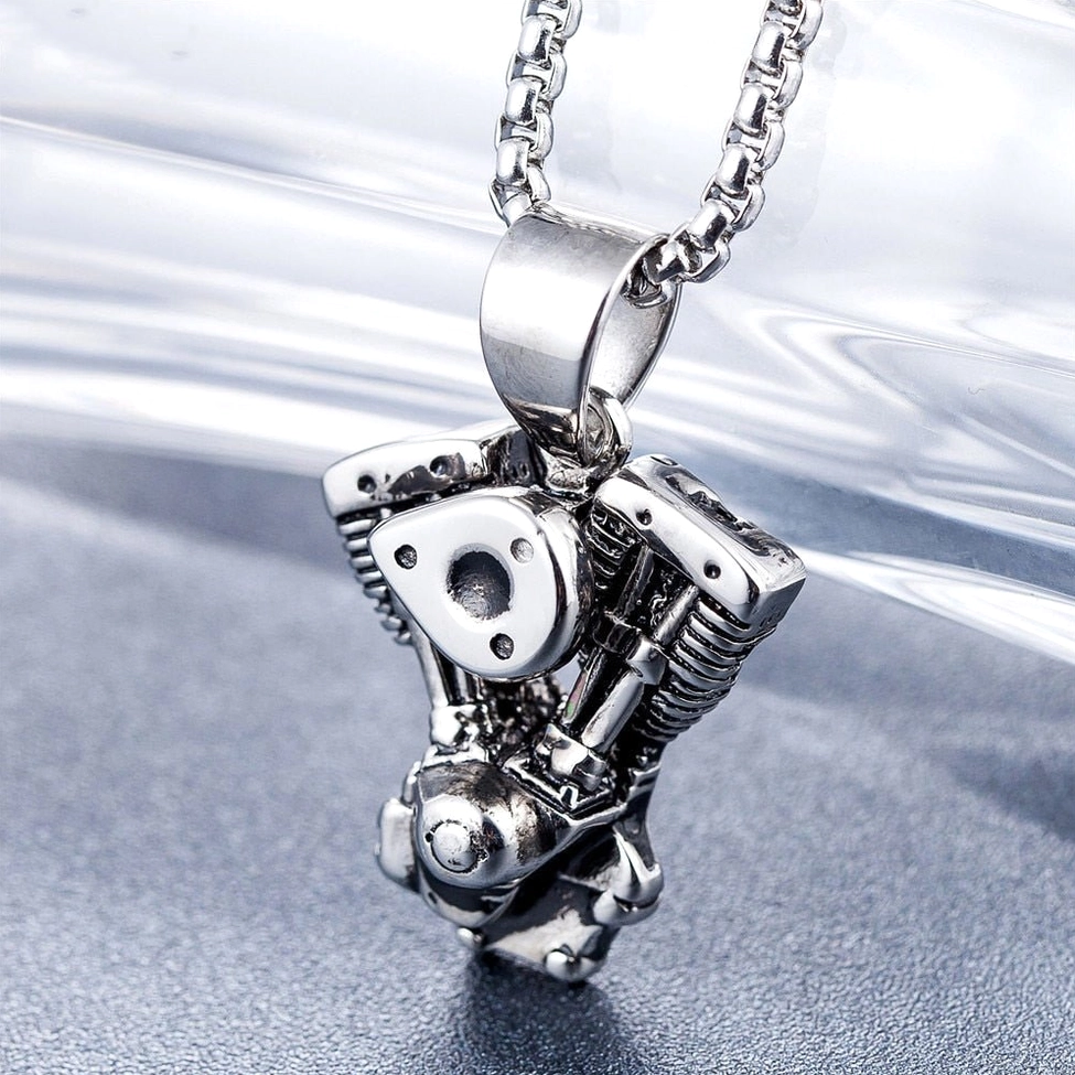 Oblique overhead shot of gothic engine pendant revealing intricate mechanical cylinder and valve details with textured finish
