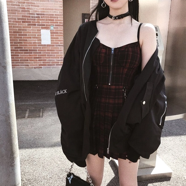 Red and black plaid gothic dress styled with black bomber jacket and choker, outdoor street style shoot showing alternative fashion coordination