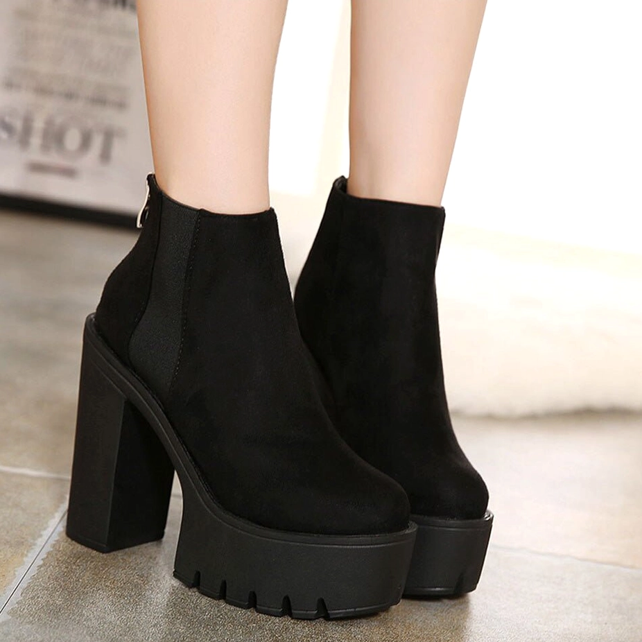 Black gothic platform ankle boots on model's feet front view, showcasing complete silhouette of round toe and side elastic panels