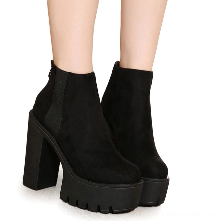 Black gothic platform ankle boots worn on female model's legs, side view displaying chunky square heel and elegant silhouette