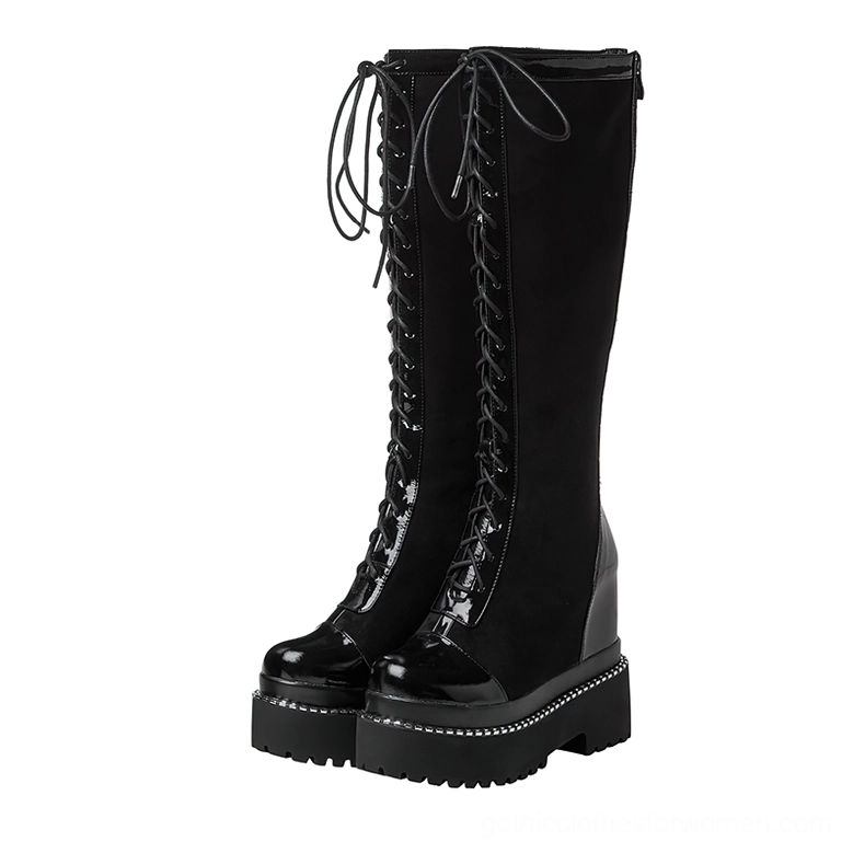 Black gothic platform knee-high boots with lace-up front and patent leather, front three-quarter view showing thick platform sole and round toe