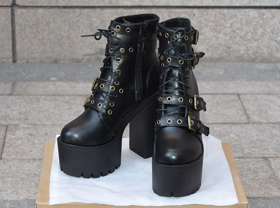 Angled side view of gothic platform buckle boots emphasizing chunky block heel structure and overall proportional design aesthetic