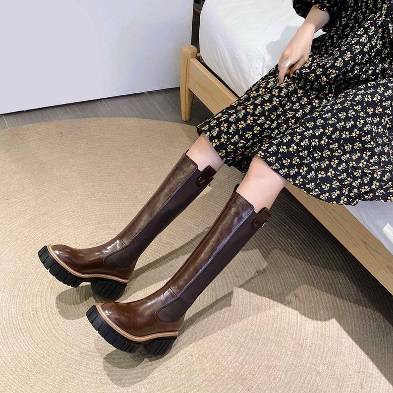 Female model wearing brown leather gothic knee-high platform boots with chunky lug sole and floral dress outfit