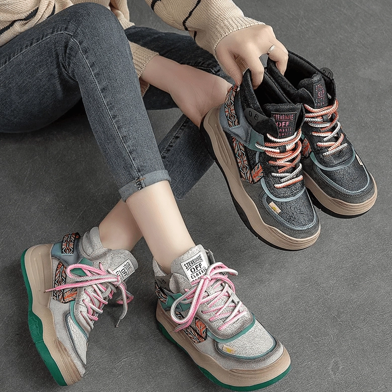 Overhead view of two pairs of gothic patchwork platform boots on model wearing denim, showing platform height and ethnic details