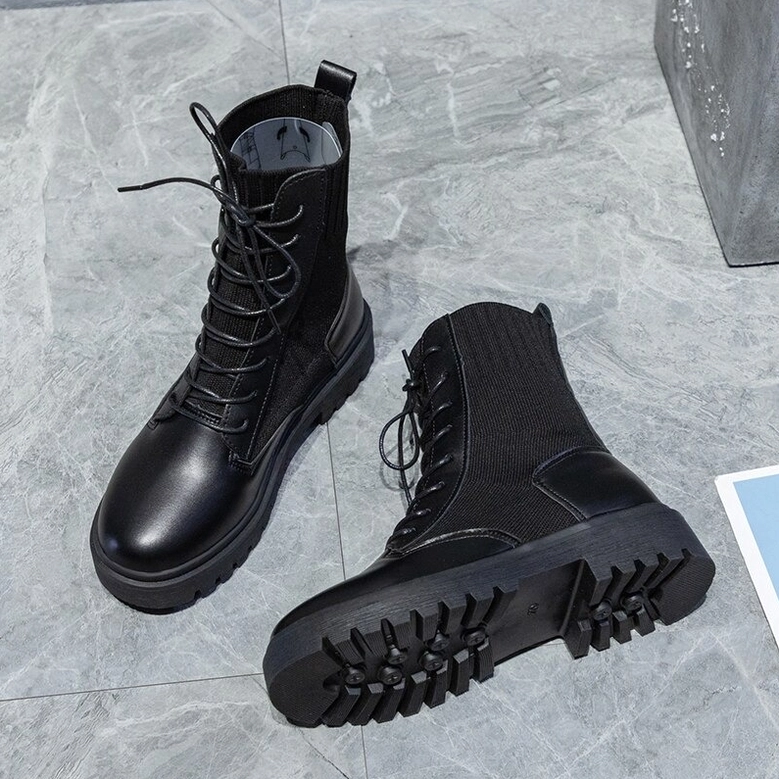 Black gothic combat ankle boots overhead view - platform lug outsole tread pattern visible on marble tile