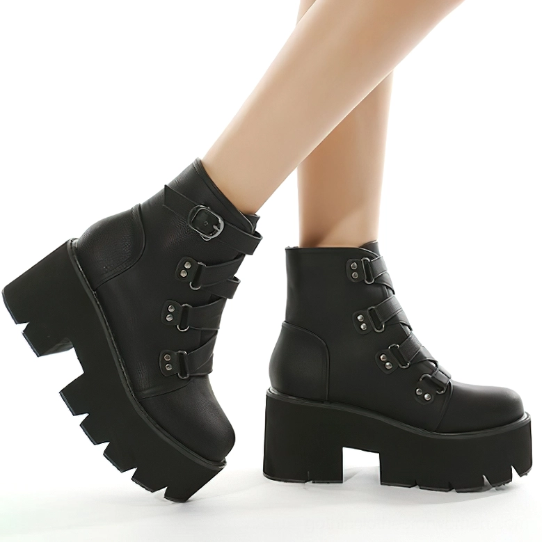 Model wearing black gothic platform ankle boots with buckle straps, low angle leg shot showing chunky heel silhouette