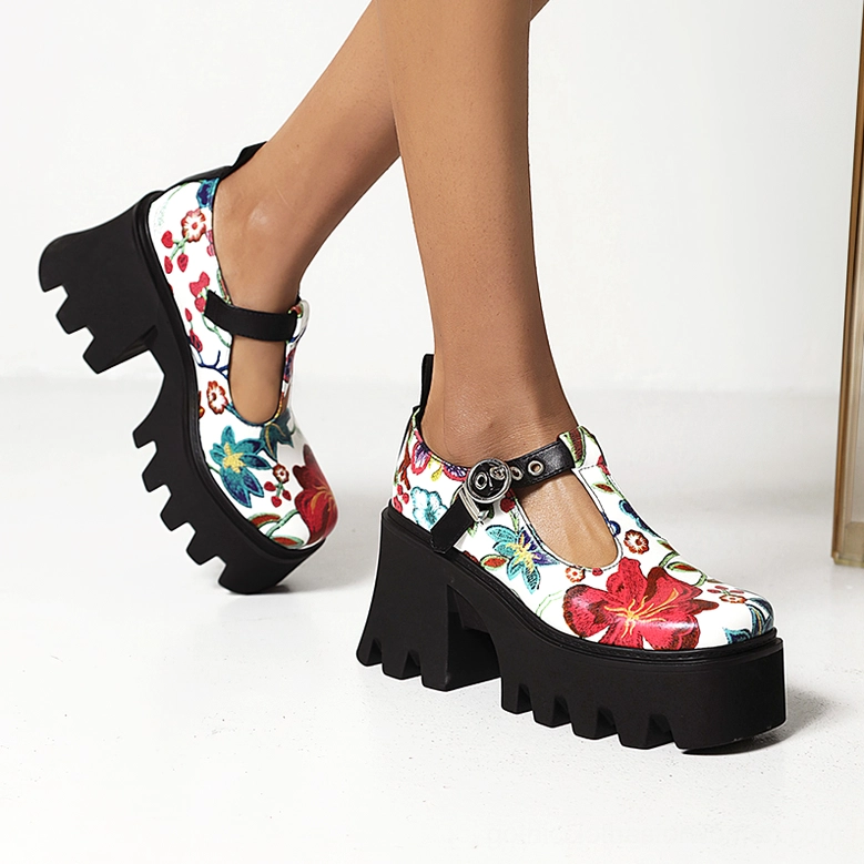 Woman wearing white and red floral gothic platform Mary Jane pumps with T-strap buckle from low side viewing angle