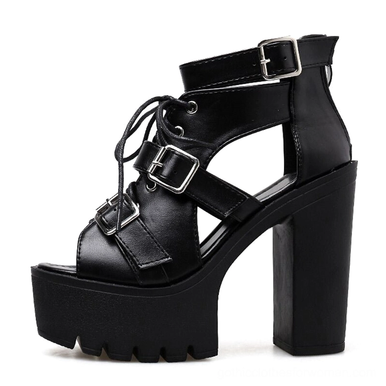 Single black platform sandal side profile showing lugged rubber sole and rear ankle buckle strap