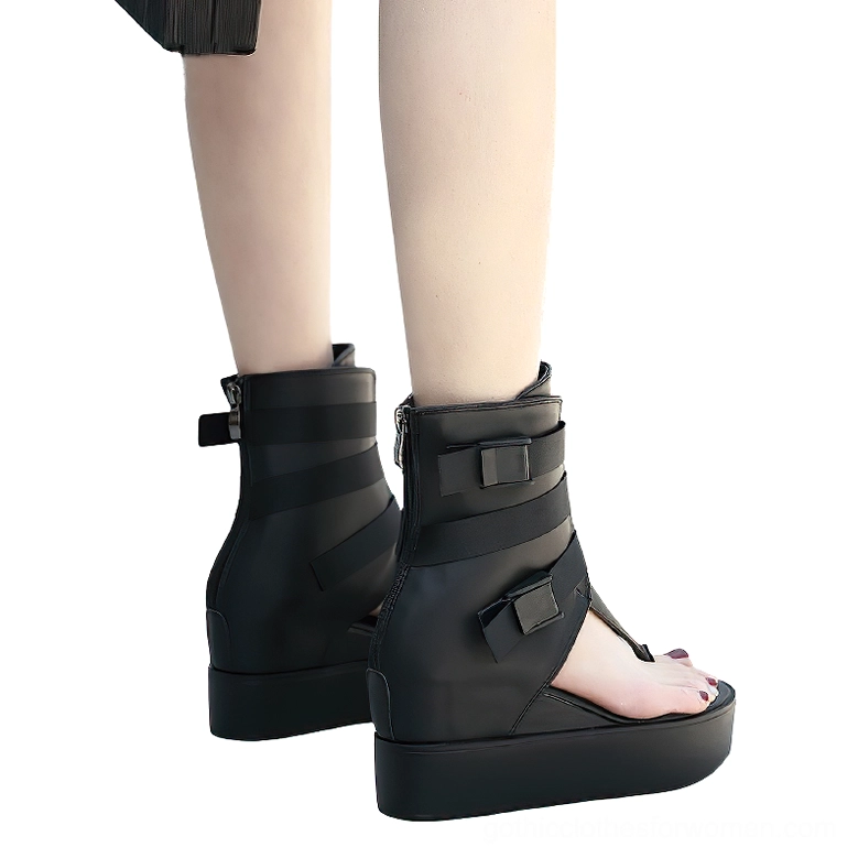 Black gothic platform sandals on model rear three-quarter view showing functional rear zipper, thick platform sole, and complete buckle strap system in action