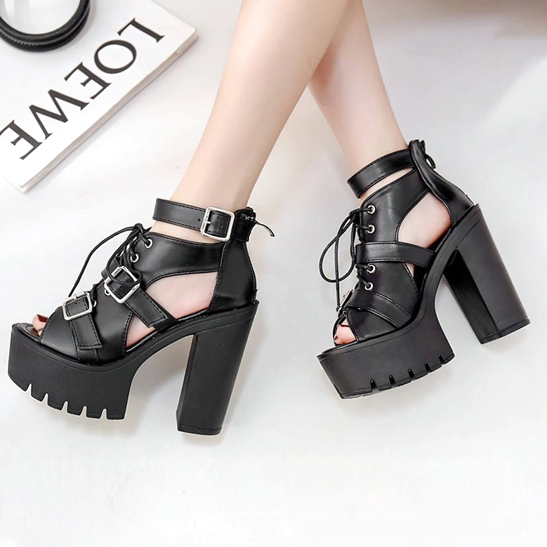 Female model wearing pair of black gothic platform sandals on feet, side-by-side view showing silhouette