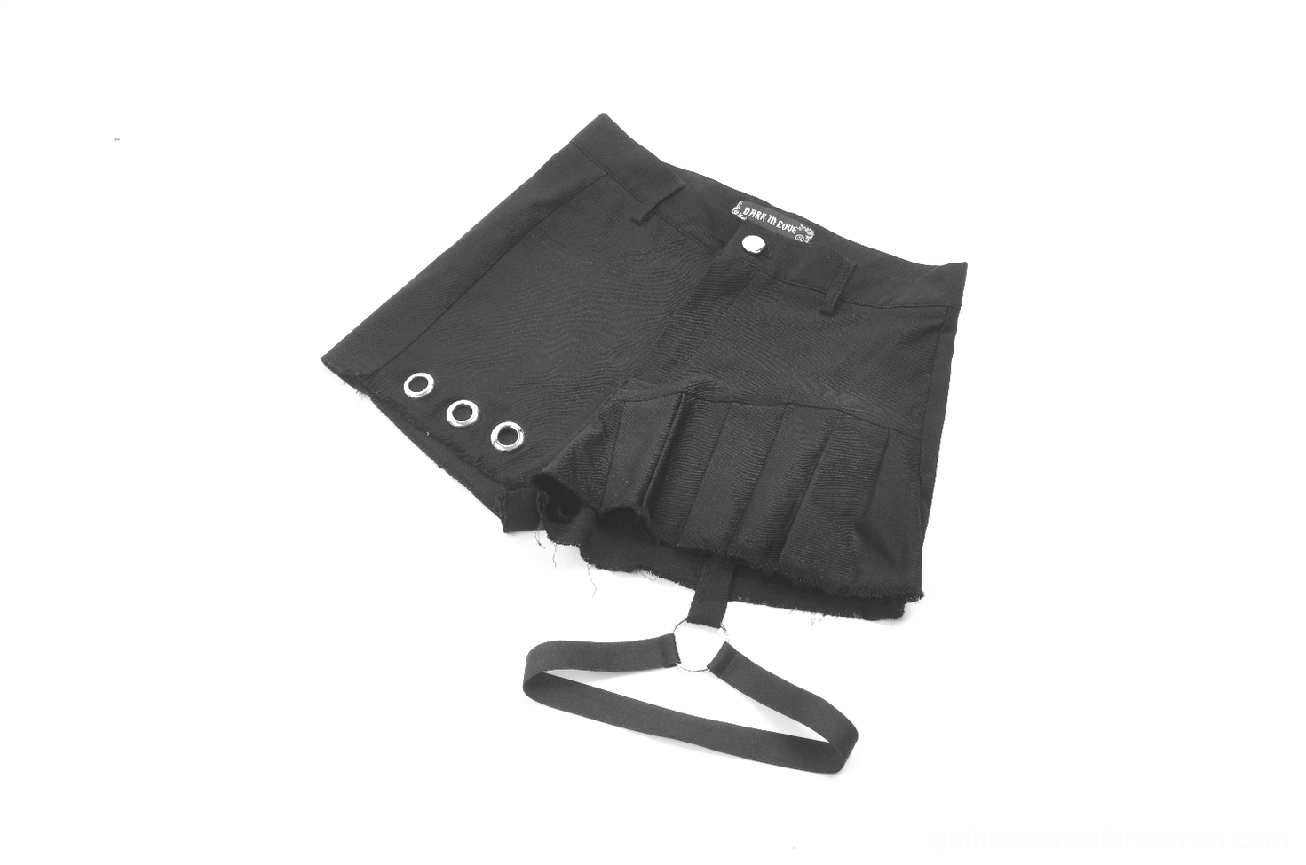 Side angle flat lay of asymmetrical gothic pleated shorts showing woven fabric texture and waist label